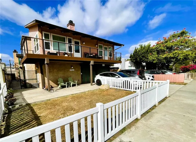 a view of a house with wooden fence