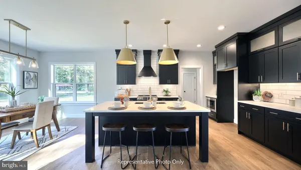 a kitchen with stainless steel appliances a dining table chairs sink and wooden floor