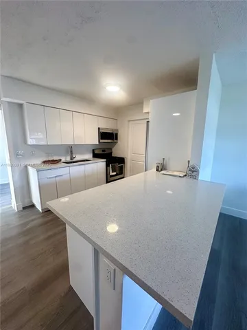 a large white kitchen with wooden floors