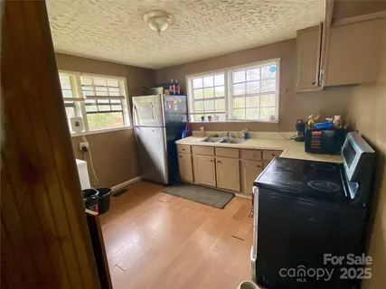 a room with a sink a window and cabinets