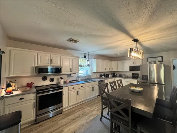 a kitchen with kitchen island granite countertop a view of table and chairs
