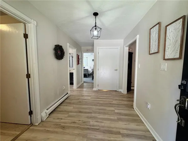 a view of a hallway with wooden floor and a cabinet