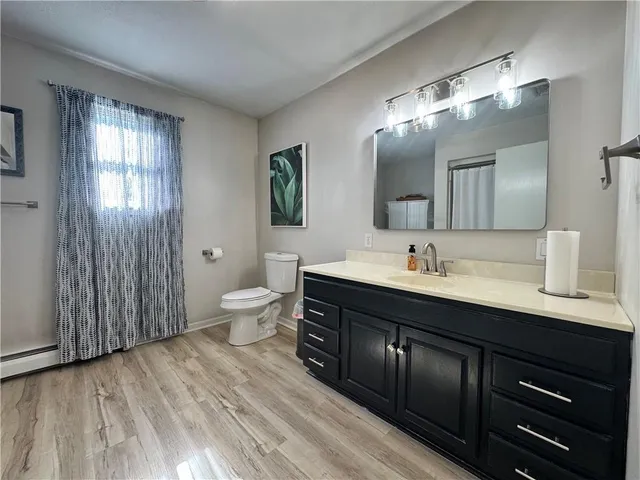 a spacious bathroom with a double vanity sink a toilet and a mirror