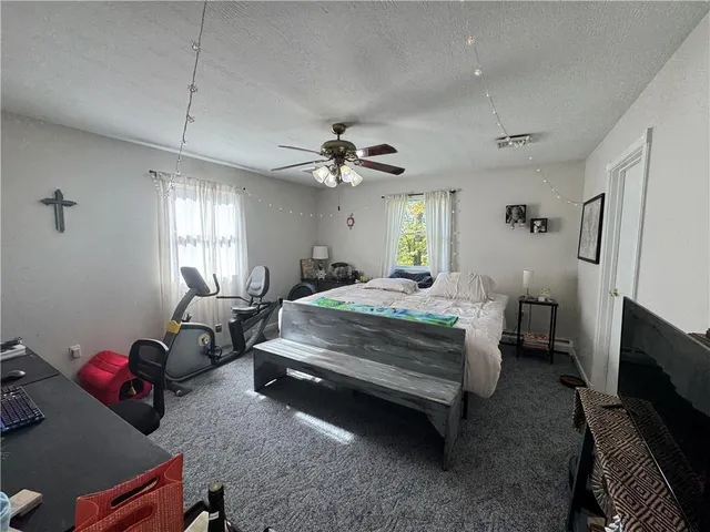 a bedroom with bed couch and window