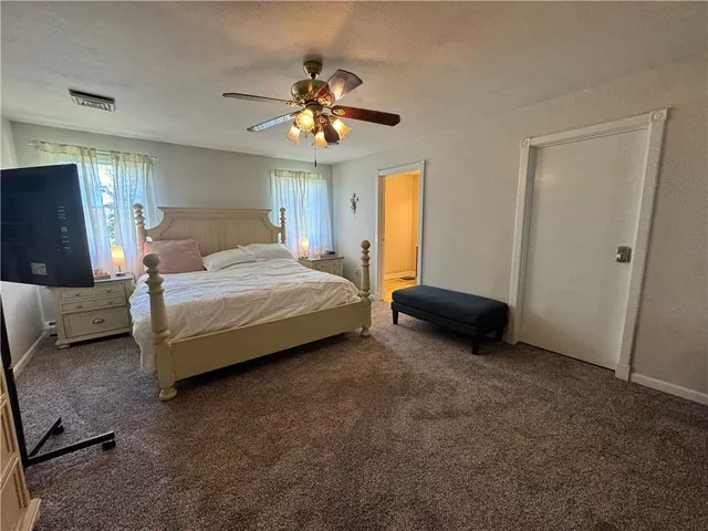 a spacious bedroom with a bed and a chandelier