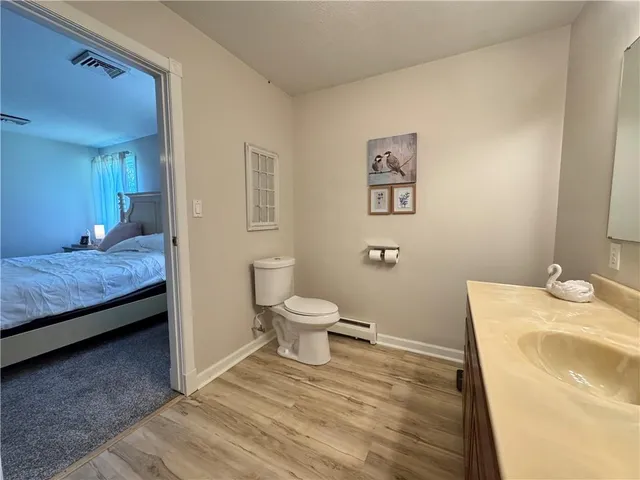a bathroom with a granite countertop toilet sink and mirror