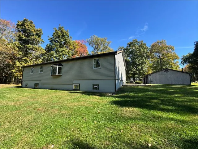 a house is sitting in middle of the green field