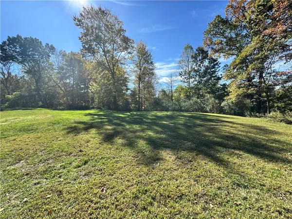 a view of a field with trees in the background
