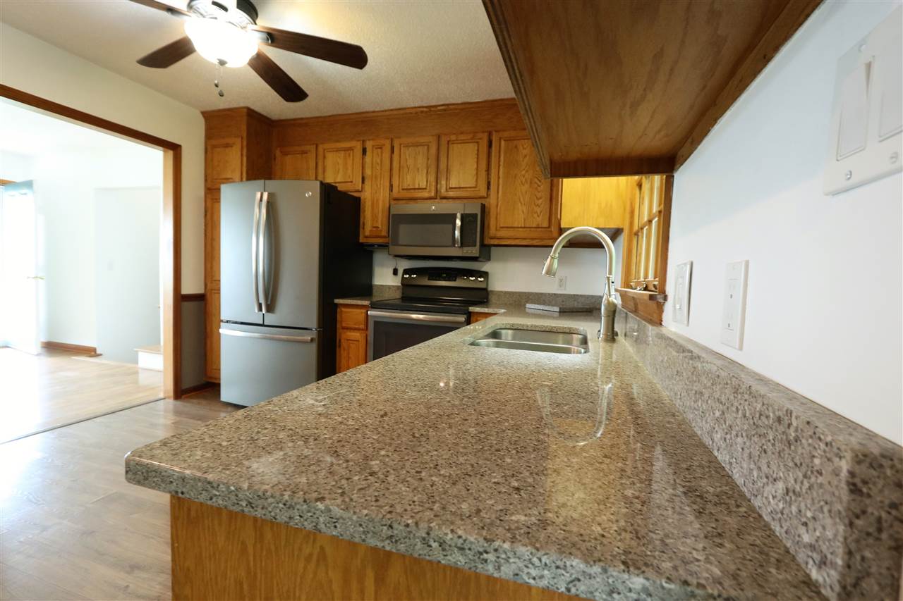 1067 Madrid Road Waynesboro, VA 22980 - Photo 18 of 48 a kitchen with granite countertop a refrigerator a sink a stove and dishwasher