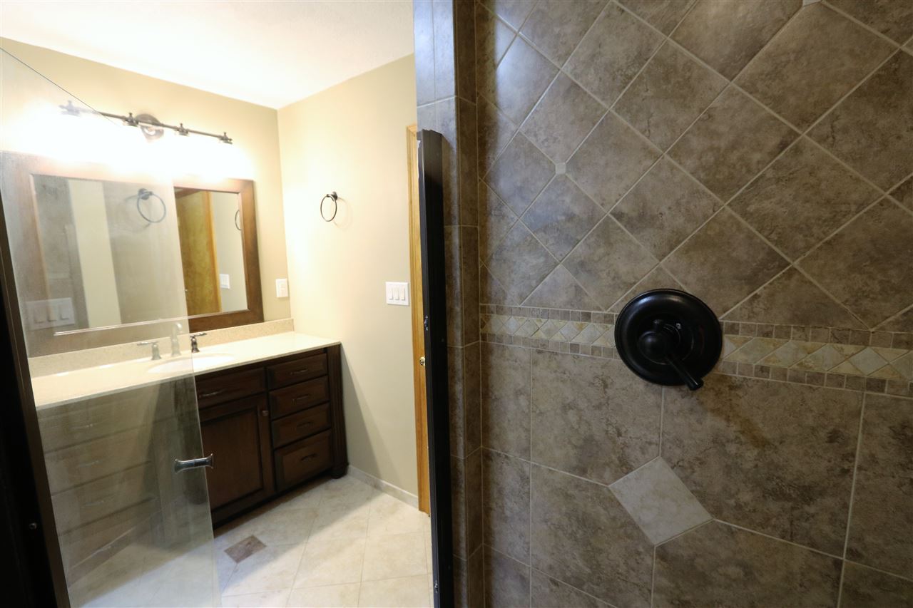 1067 Madrid Road Waynesboro, VA 22980 - Photo 29 of 48 a bathroom with a granite countertop sink a mirror and a shower