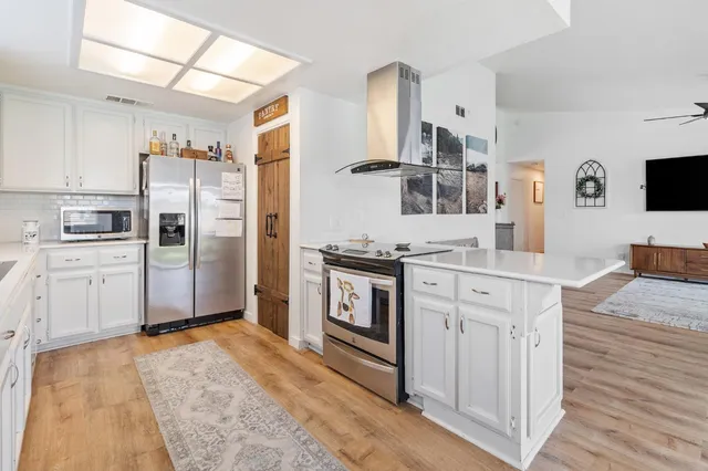 a kitchen with stainless steel appliances granite countertop a refrigerator stove and sink