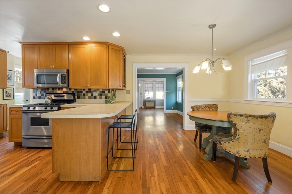 10 Bowker Street Lexington, MA 02421 - Photo 7 of 24 a kitchen with stainless steel appliances a kitchen island hardwood floor sink stove dining table and chairs