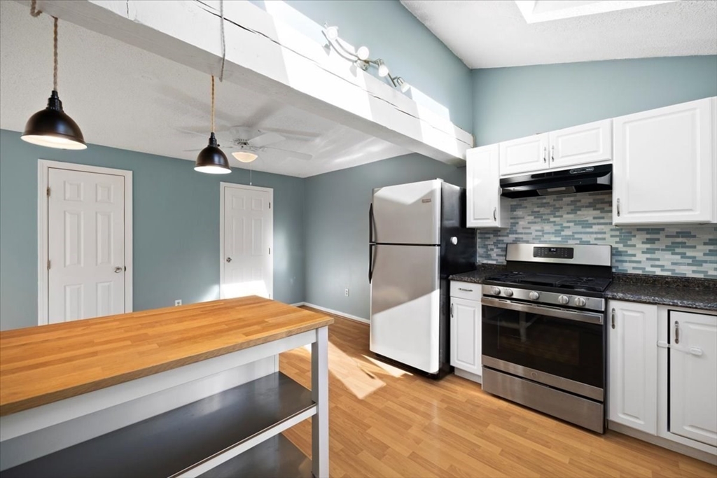 6 Robin Circle, Unit 1 Norton, MA 02766 - Photo 15 of 38 a kitchen with kitchen island a counter top space a sink stainless steel appliances and cabinets