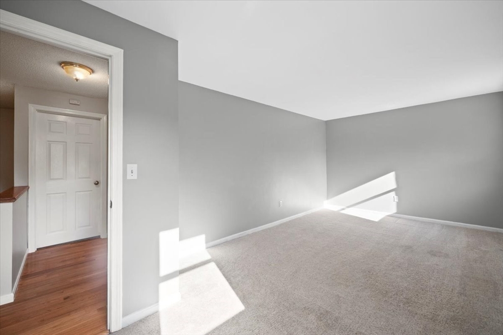 6 Robin Circle, Unit 1 Norton, MA 02766 - Photo 27 of 38 a view of an empty room and wooden floor