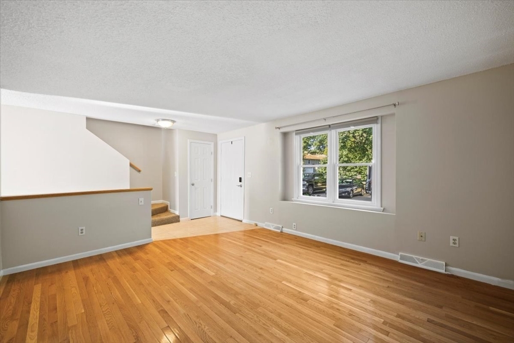 6 Robin Circle, Unit 1 Norton, MA 02766 - Photo 4 of 38 a view of empty room with wooden floor and fan