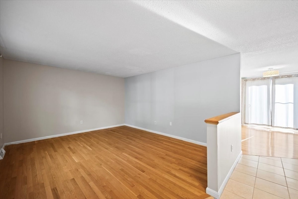 6 Robin Circle, Unit 1 Norton, MA 02766 - Photo 6 of 38 a view of an empty room with wooden floor and a window