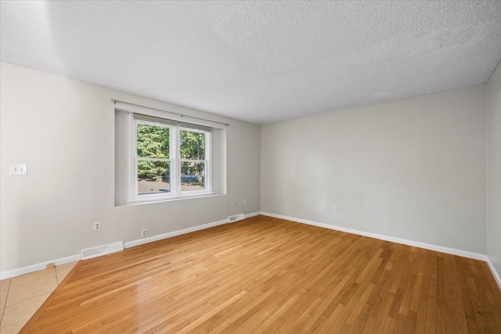 6 Robin Circle, Unit 1 Norton, MA 02766 - Photo 7 of 38 a view of an empty room with wooden floor and a window