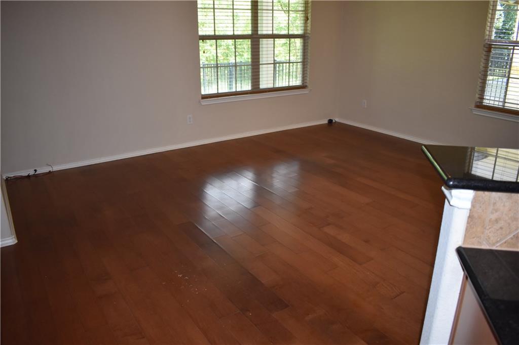 1310 West Parmer Lane, Unit 1503 Austin, TX 78727 - Photo 9 of 26 Spare room with healthy amount of natural light and dark wood finished floors