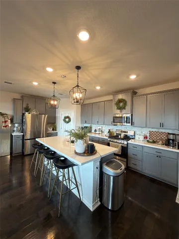 a kitchen with sink a stove and chairs
