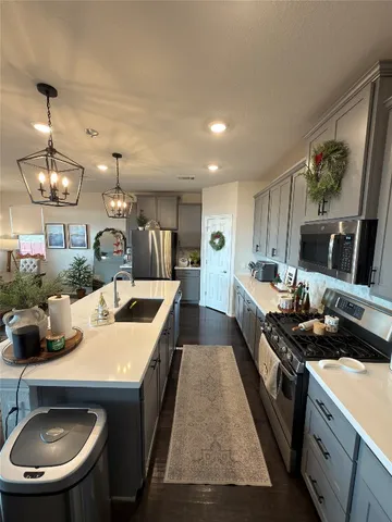 a large kitchen with a stove a refrigerator a sink a dining table and chairs