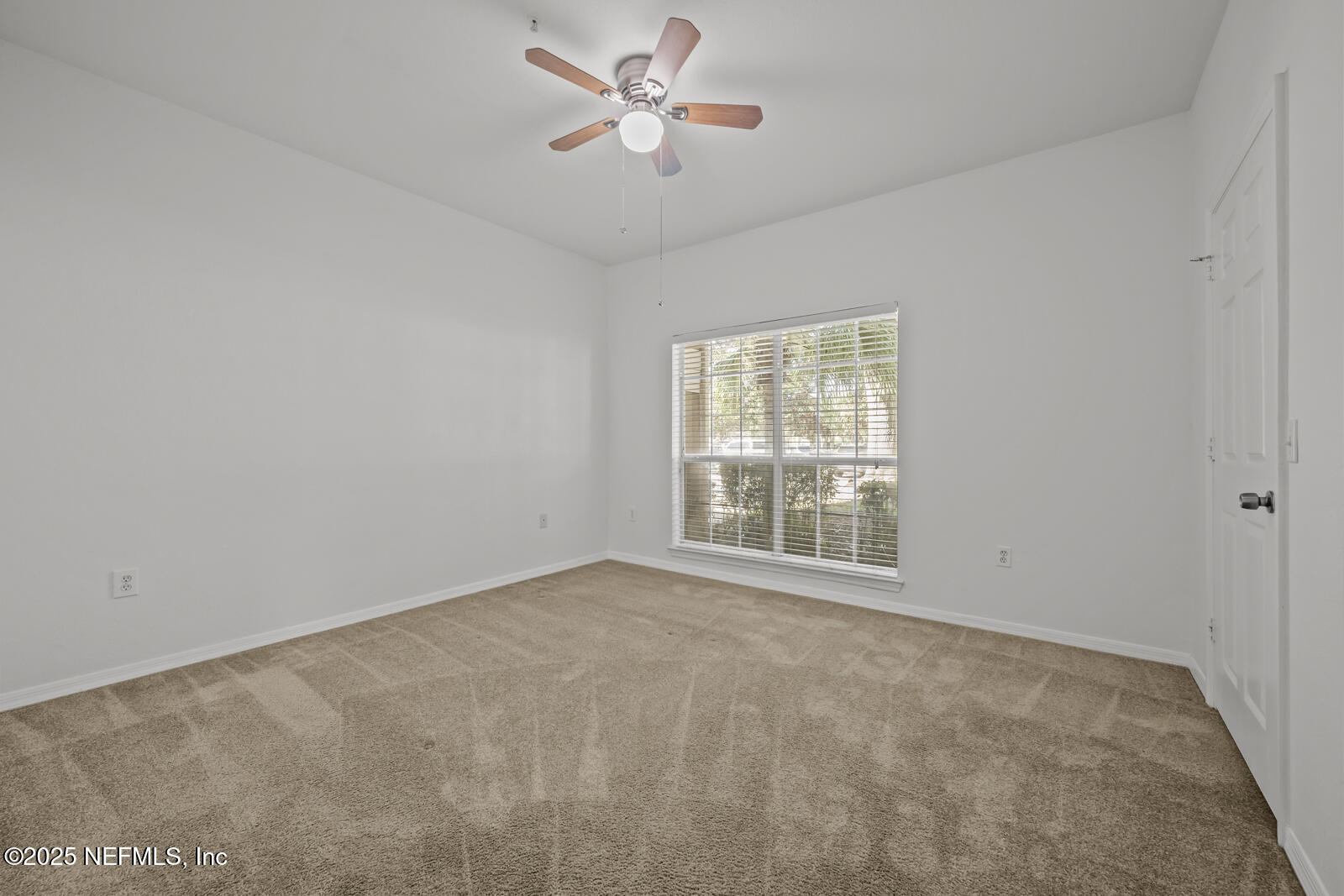 10961 Burnt Mill Road, Unit 1217 Jacksonville, FL 32256 - Photo 18 of 59 an empty room with chandelier fan and windows