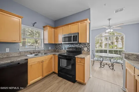 a bathroom with a granite countertop sink a light fixture and a mirror