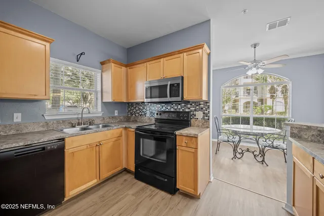 a bathroom with a granite countertop sink a light fixture and a mirror