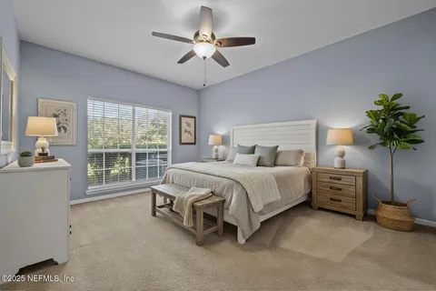 an empty room with chandelier fan and windows