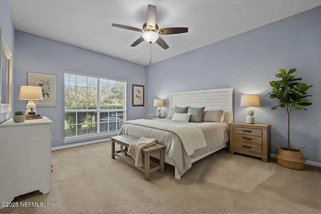 an empty room with chandelier fan and windows