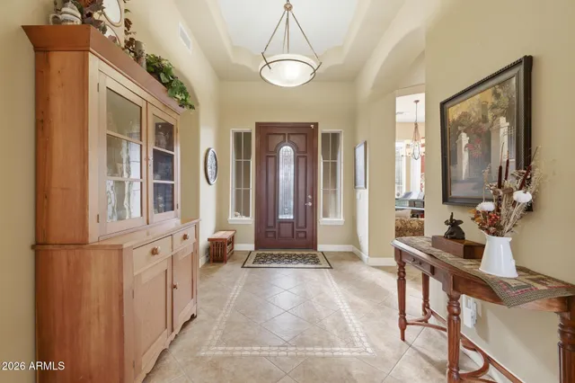 a view of a house with potted plants and a large tree