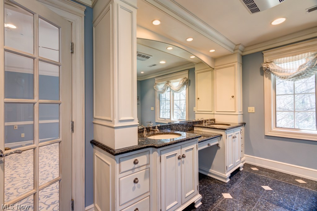1739 Chartley Road Gates Mills, OH 44040 - Photo 19 of 25 In the Master Bath, Blue Pearl Granite graces the floors and tops the white Quality Custom Vanities with glass knobs, dual sinks, and dual medicine cabinets.