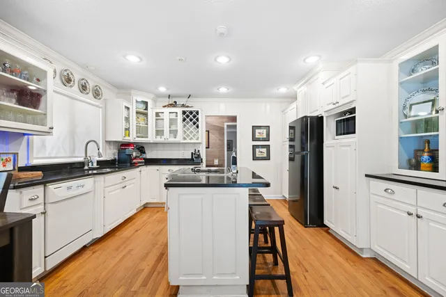 a kitchen with stainless steel appliances granite countertop sink stove refrigerator and cabinets
