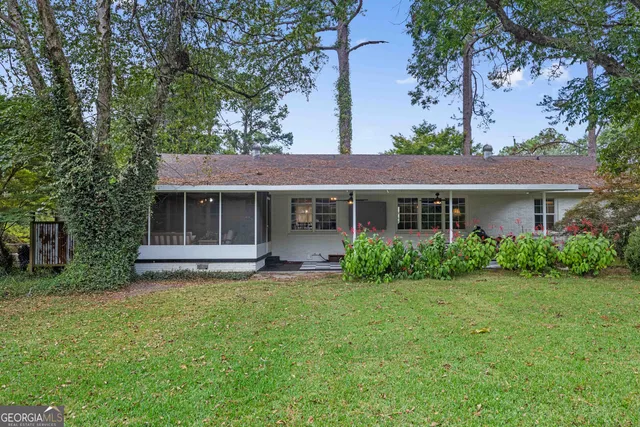 a front view of a house with a garden and yard