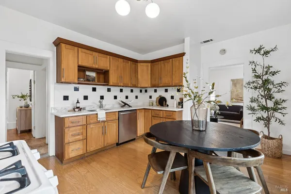a kitchen with stainless steel appliances a dining table chairs and chandelier