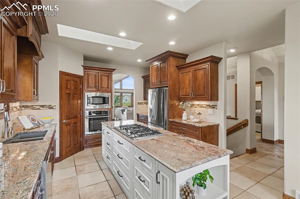 4215 Star Ranch Road Colorado Springs, CO 80906 - Photo 17 of 44 a kitchen with stainless steel appliances kitchen island granite countertop a refrigerator and a stove top oven