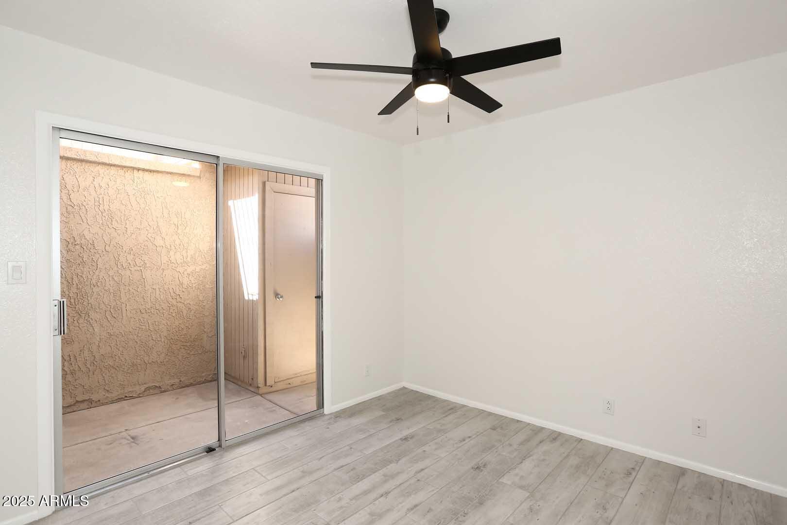 93 North Cooper Road, Unit 32 Chandler, AZ 85225 - Photo 17 of 33 a view of a room with wooden floor and a ceiling fan