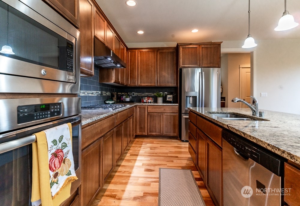 3825 221st Place Southeast Bothell, WA 98021 - Photo 19 of 40 a kitchen with stainless steel appliances granite countertop a sink a stove and a refrigerator