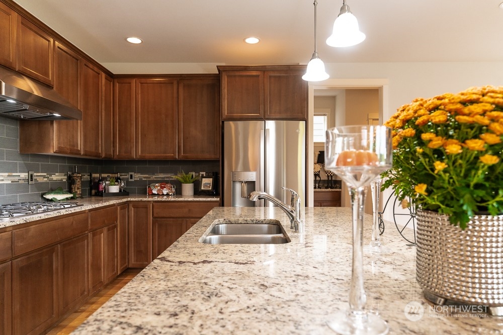 3825 221st Place Southeast Bothell, WA 98021 - Photo 20 of 40 a kitchen with stainless steel appliances kitchen island granite countertop a refrigerator and a stove top oven