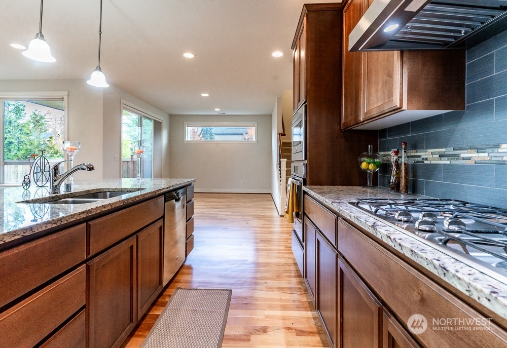 3825 221st Place Southeast Bothell, WA 98021 - Photo 21 of 40 a kitchen with stainless steel appliances granite countertop wooden cabinets a stove top oven a sink and dishwasher