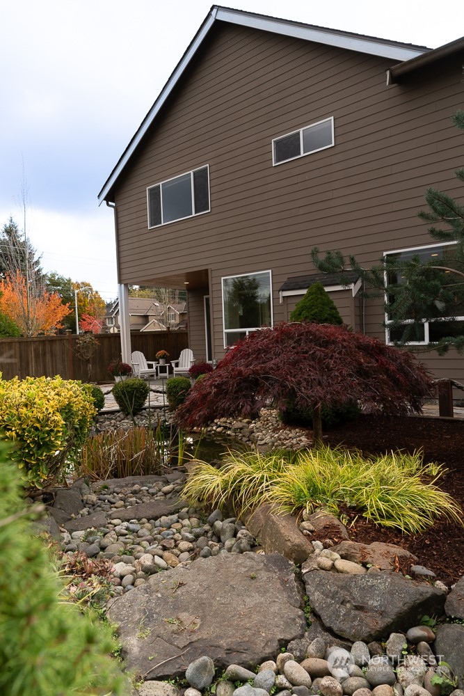 3825 221st Place Southeast Bothell, WA 98021 - Photo 9 of 40 a view of a house with a yard and lawn chairs with wooden fence