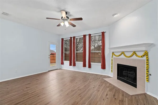 a view of an empty room with a fireplace and a window
