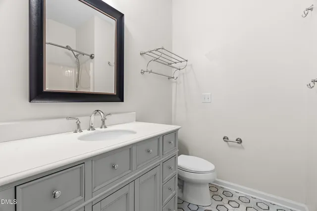 a bathroom with a granite countertop toilet sink and mirror