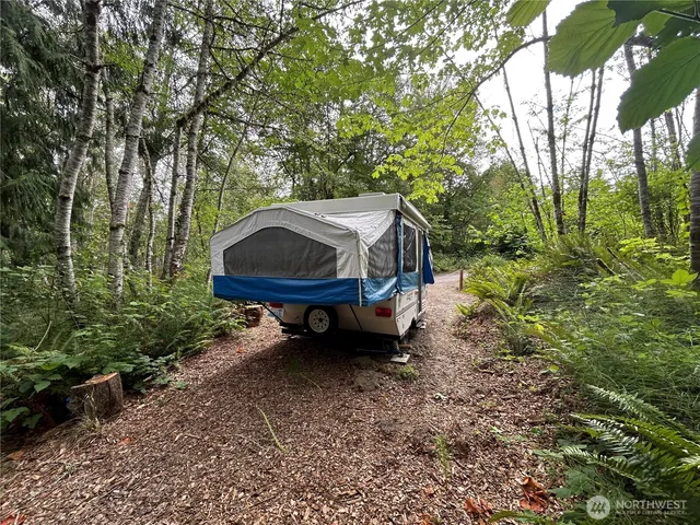 a backyard of a house with barbeque oven table and chairs