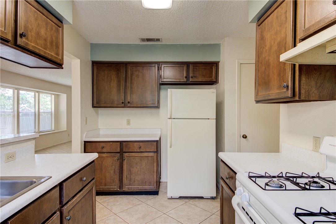 12012 Swallow Drive Austin, TX 78750 - Photo 13 of 33 a kitchen with stainless steel appliances granite countertop a sink stove and refrigerator