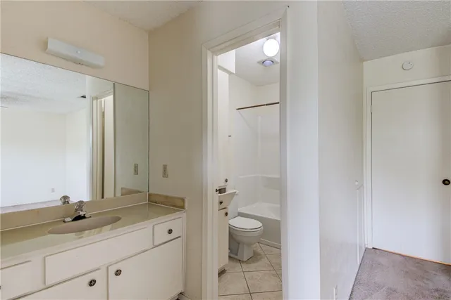 a spacious bathroom with a granite countertop sink toilet and shower