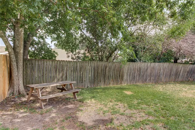 a backyard of a house with table and chairs