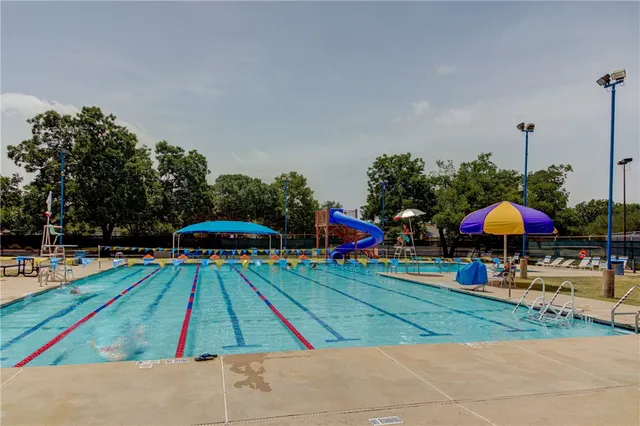 a view of a backyard with chairs and umbrellas