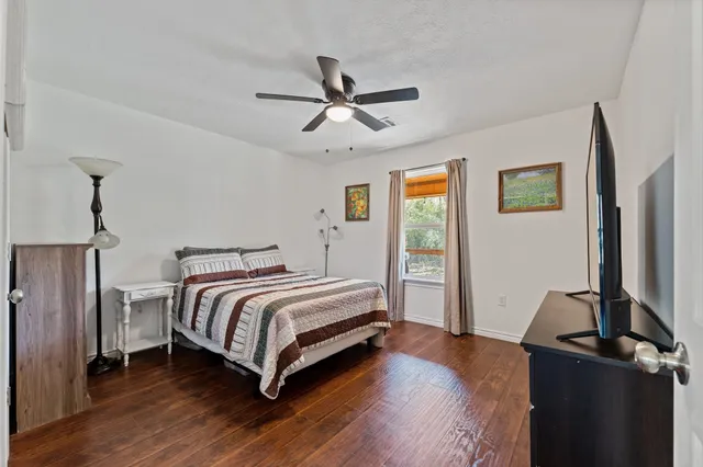 a bedroom with bed and wooden floor