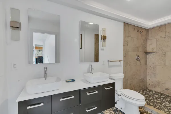 a bathroom with a sink toilet a mirror and shower