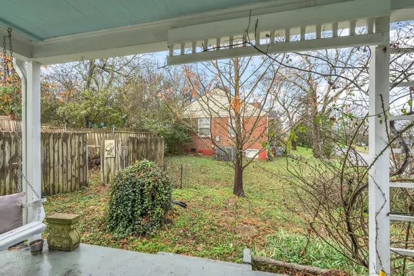 a backyard of a house with large trees and plants